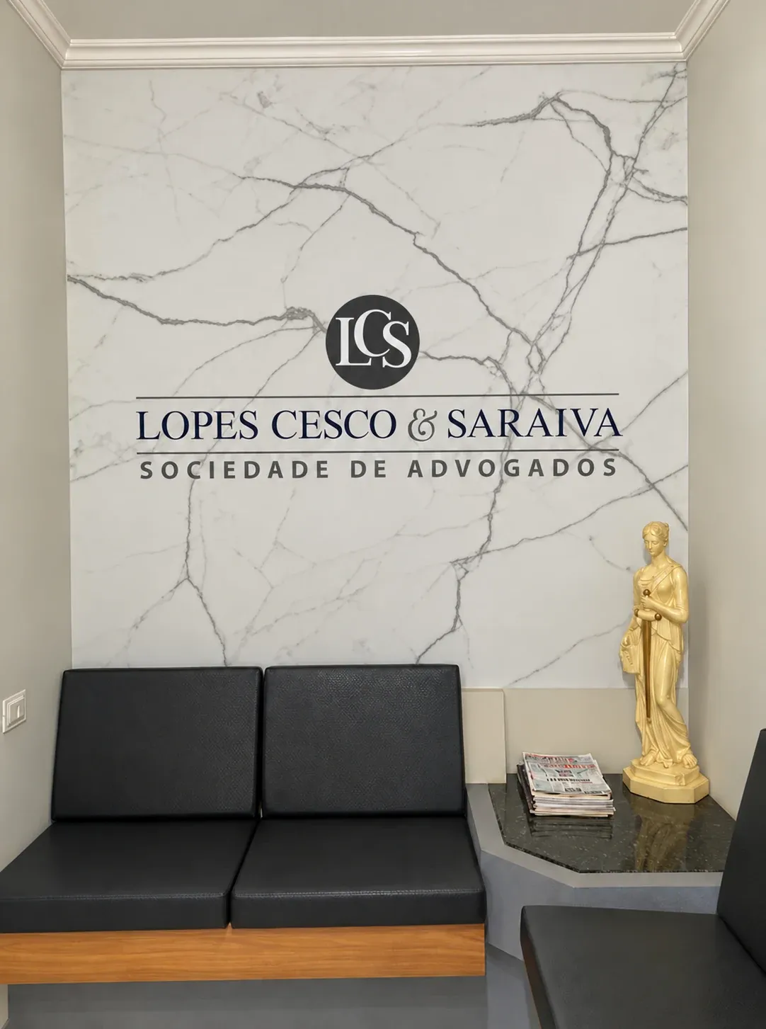 Recepção da Lopes Cesco & Saraiva com o logo na parede de mármore
